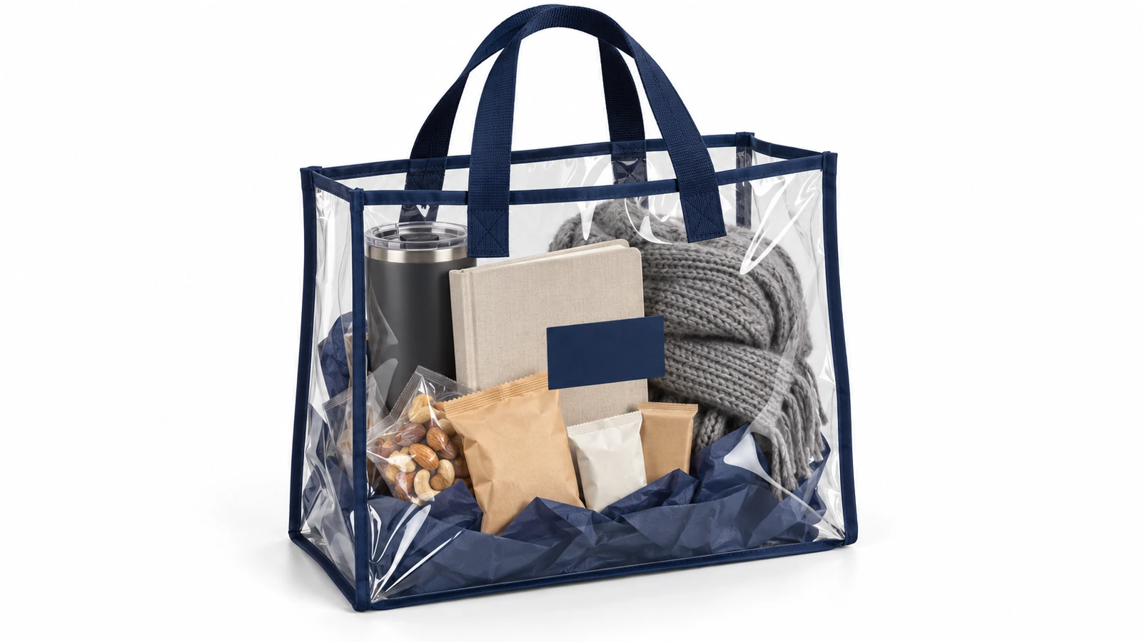 Sacola transparente de PVC com debrum azul-marinho contendo um kit de presente corporativo com copo térmico, caderno, petiscos e um lenço dobrado, tudo visível através da sacola