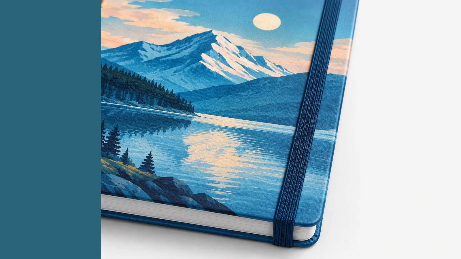Detalhe da capa impressa e do elástico Close-up ilustrativo de uma capa impressa com paisagem de lago de montanha, elástico azul e bloco de páginas