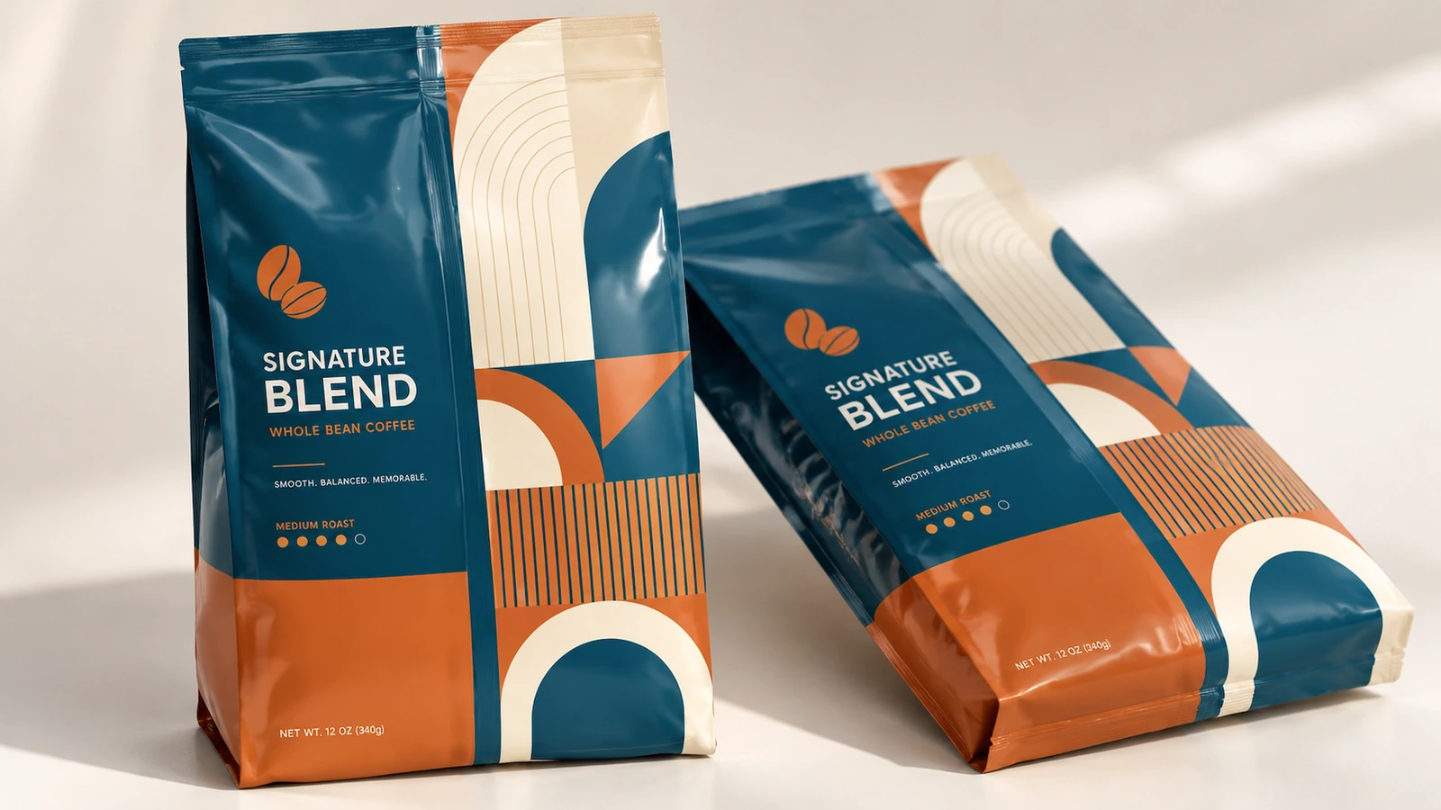 Exposição de bolsas para café Uma bolsa para café em pé e outra deitada, com arte em azul-petróleo e laranja