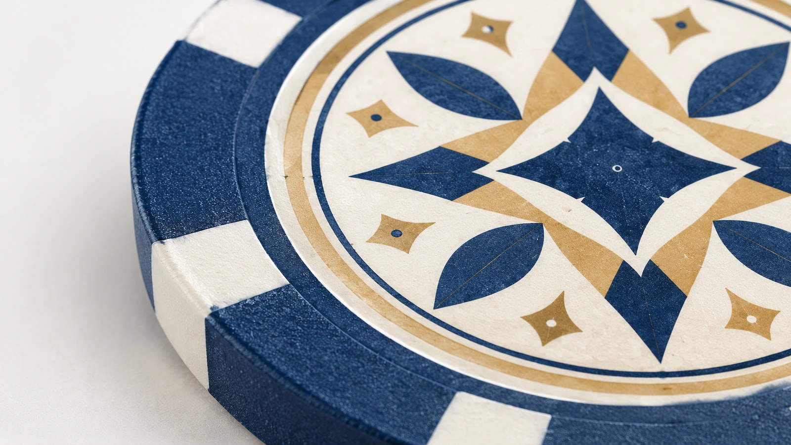 Detalhe da arte e das marcas de borda de fichas de pôquer Close-up de arte geométrica azul e dourada em ficha de pôquer com marcas de borda brancas