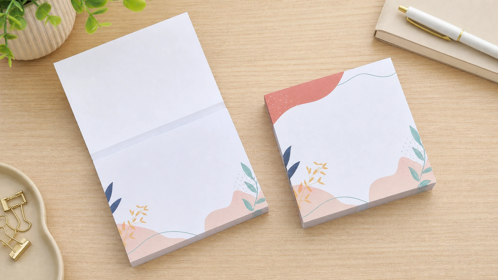 Blocos de notas impressos, abertos e fechados Bloco de notas floral com uma folha levantada ao lado de um bloco fechado correspondente