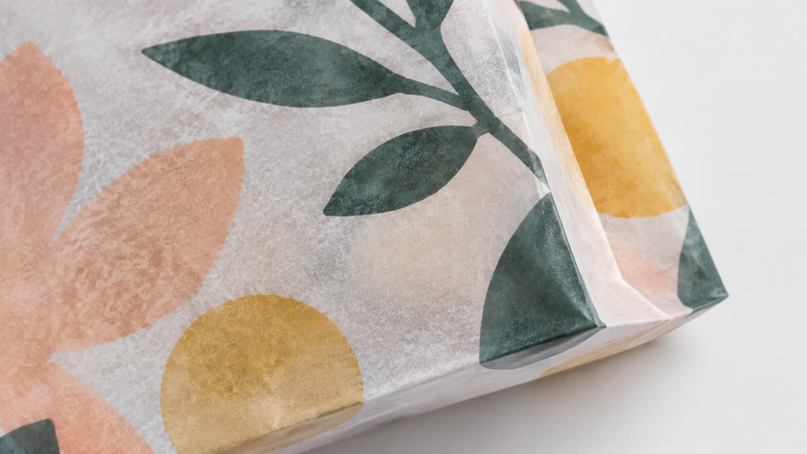 Textura do papel impresso e dobra da base Detalhe ampliado do papel com estampa floral e de um canto de base dobrado